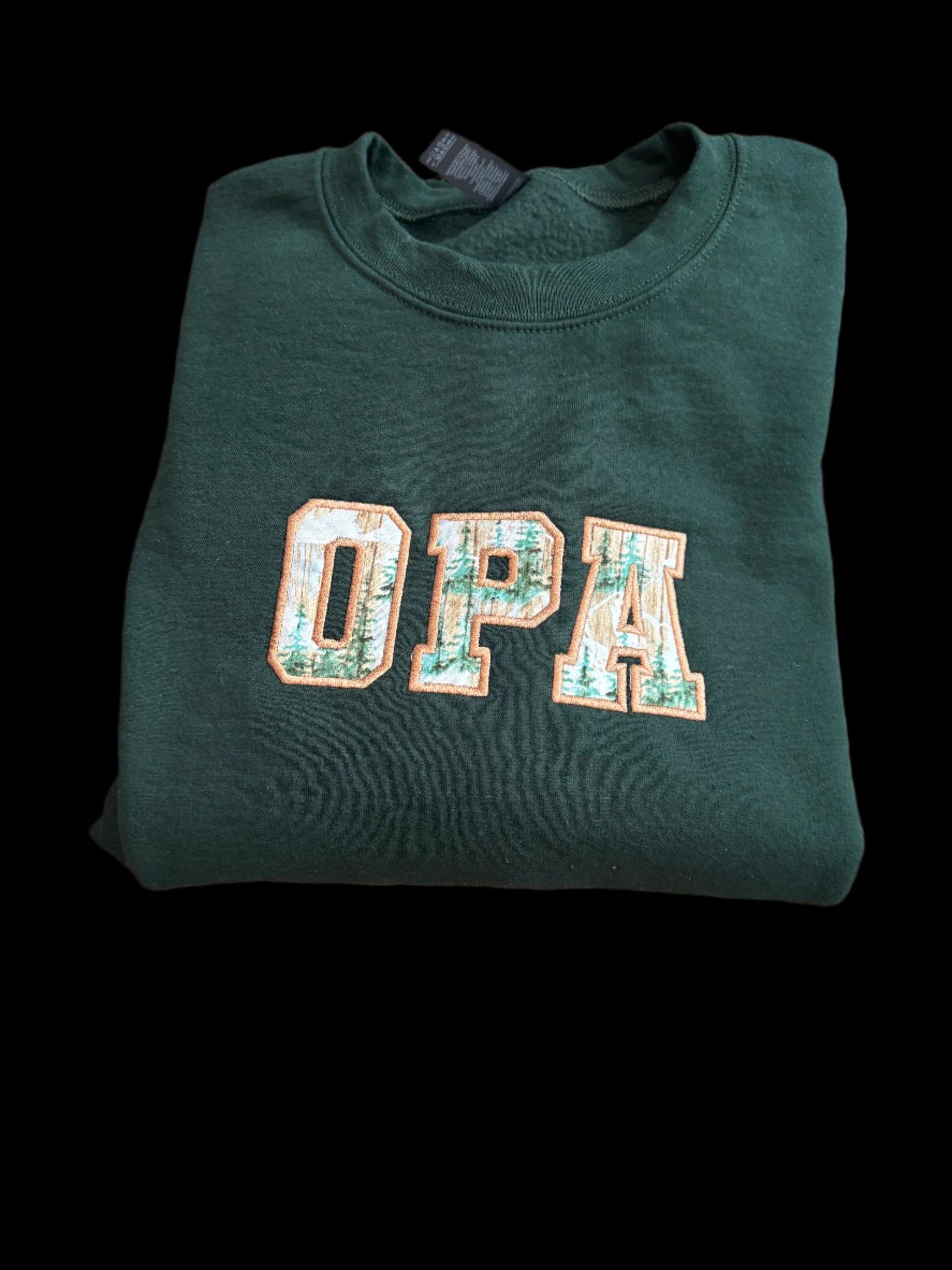 Green sweatshirt with 'OPA' text on a woven surface