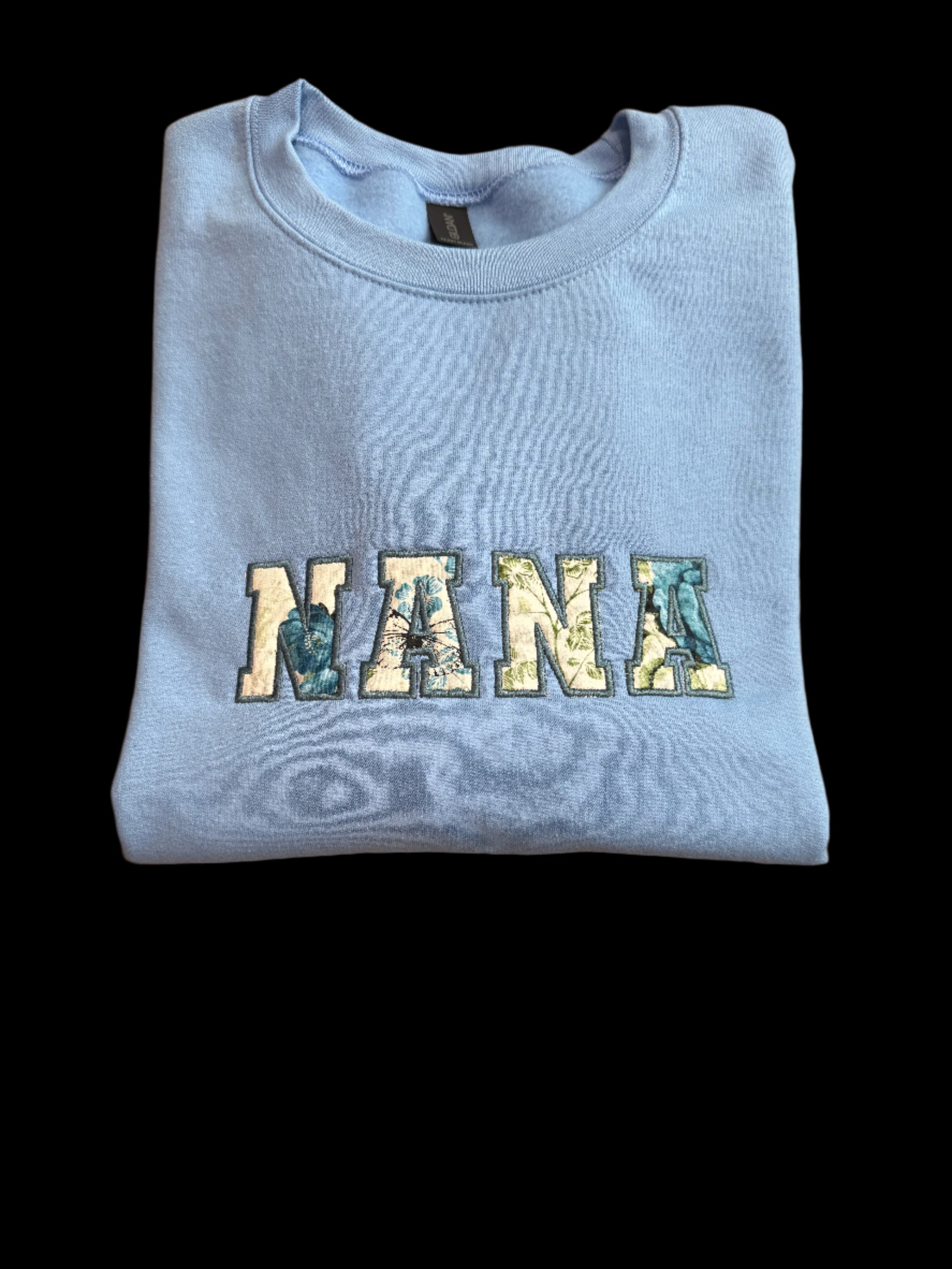 Light blue sweatshirt with 'Nana' printed on it.